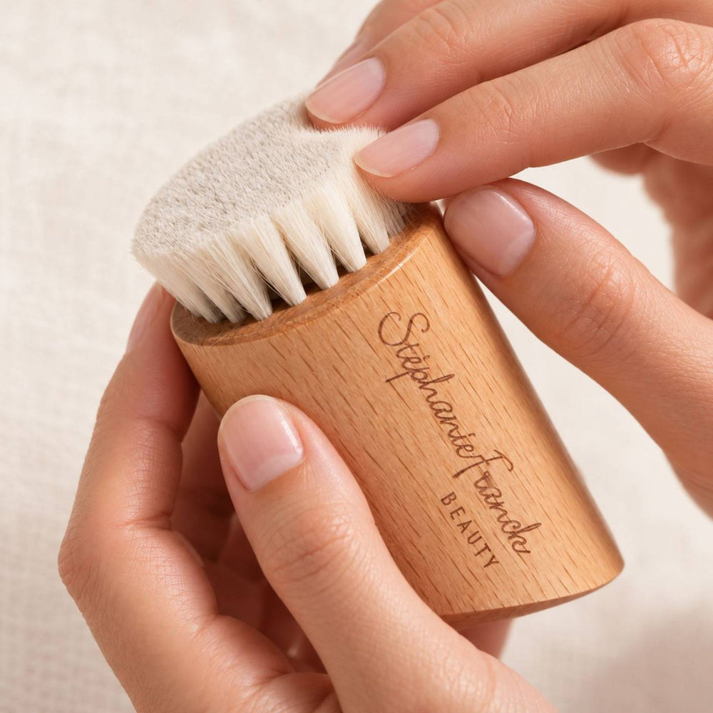 Main tenant une brosse visage